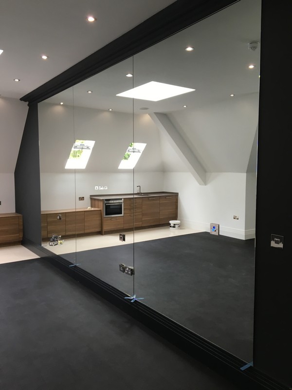 Frameless glass partition in loft conversion by Gerrards Cross glaziers